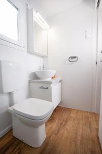 een witte badkamer met een toilet en een wastafel bij Luxury Mobile Home Marbella 167 -Terra Park SpiritoS in Kolan