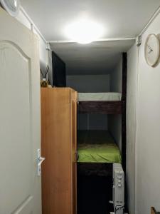 a small room with a bunk bed and a clock at Back Garden Cabin Home with Terrace(Self Check-in) 