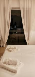 Una cama blanca con dos platos y toallas. en Hotel Rania en Loutra Edipsou