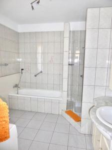 een badkamer met een douche, een bad en een wastafel bij Dein Appartement Sunset View und Meer in La Pared