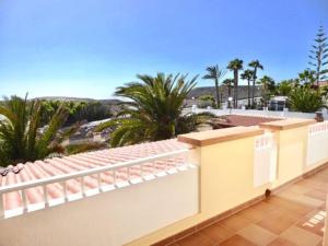 een balkon met uitzicht op het strand en de palmbomen bij Dein Appartement Sunset View und Meer in La Pared
