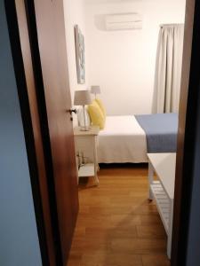 a small bedroom with a bed and a table at Guia Guest House in São Bartolomeu de Messines