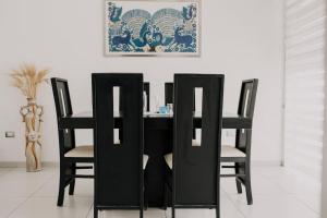 a black dining room table with four black chairs at Amazing House in Aguacalientes with Pool in Aguascalientes