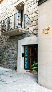un edificio in pietra con porta e balcone di Cal Belló Casa rural a Lleida