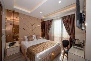 a hotel room with a bed and a window at Luxury Airport Hotel in Arnavutköy