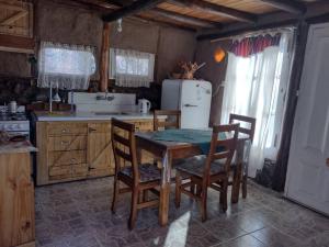 a kitchen with a table and chairs and a refrigerator at Hospedaje de Barro in La Consulta