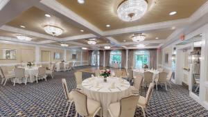 uma sala de banquetes com mesas e cadeiras brancas em Avon Old Farms Hotel em Avon