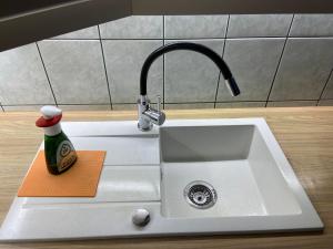 un fregadero de cocina con una botella de agente de limpieza. en Bory Apartman, zárt udvari parkolás, en Székesfehérvár