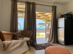 a living room with a refrigerator and a view of the ocean at Casita Del Mar Oceanfront Romantic Retreat In Islote in Arecibo