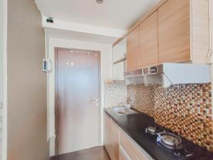 een kleine keuken met een wastafel en een koelkast bij RedLiving Apartemen The Suites Metro - King Property Tower C in Bandung