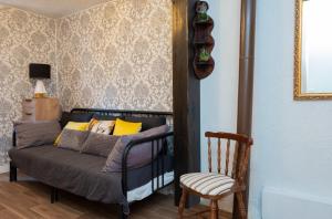 um quarto com uma cama e uma cadeira num quarto em Casa Rural La Pinara em La Adrada