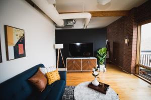 uma sala de estar com um sofá azul e uma televisão em Spacious Loft Over Coffee Shop - Romantic Downtown Escape em Greeley