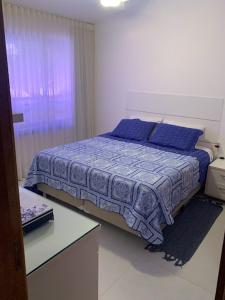 イタシミリンにあるItacimirim vilage Villas da Praiaのベッドルーム1室(青い掛け布団付きのベッド1台付)