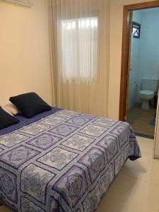 Itacimirim vilage Villas da Praia في إيتاسيميريم: غرفة نوم بسرير وحمام مع مرحاض