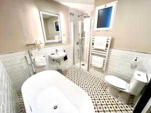 a bathroom with a tub and a toilet and a sink at Hostal La Canonja in Tremp