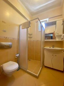 y baño con ducha, aseo y lavamanos. en Yalcin Hotel & Villas, en Ölüdeniz