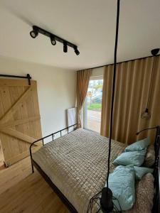 a bedroom with a bed and a large door at Sea & Home in Gąski