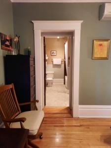 a hallway of a bathroom with a toilet and a chair at Le 100 St-Laurent in Louiseville