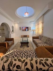 sala de estar con 2 sofás y mesa de cristal en Djerba Dar BAYA en Houmt El Souk