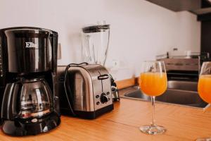 a blender and a glass of orange juice on a counter at Modern House in gated community with green gardens in Aguascalientes