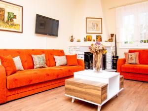 a living room with an orange couch and a table at ZeusPlace Valentina's house Elatochori in Elatochori