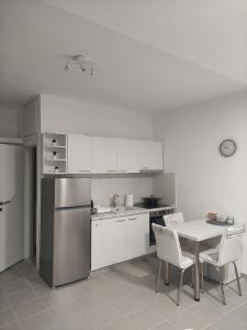 a kitchen with white cabinets and a table and chairs at Kilkis Central Studio in Kilkis