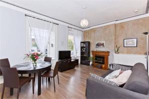 een woonkamer met een bank, een tafel en een televisie bij 1 Bedrooms Flat in Central Edinburgh Haymarket, Heart of Edinburgh Flat Sleeps 4 , in Edinburgh