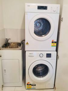 a washer and dryer next to a sink at High Rise Unit in front of Crown with Free Parking in Melbourne