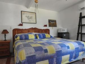 - une chambre avec un lit doté d'une couette bleue et jaune dans l'établissement Habitación independiente a pie del lago con AC, à Tequesquitengo