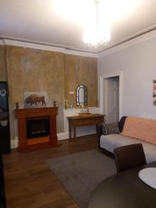 een woonkamer met een bank en een open haard bij 1 Bedrooms Flat in Central Edinburgh Haymarket, Heart of Edinburgh Flat Sleeps 4 , in Edinburgh