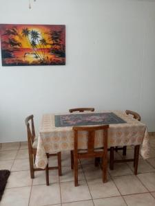 a table with two chairs and a table and a painting at Happy days in Amanzimtoti