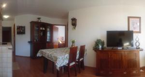 a dining room with a table and a flat screen tv at Skalna View Apartament z widokiem dwie sypialnie i salon balkon parking in Karpacz +5 photos