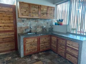 cocina con armarios de madera y encimera azul en CASA KILLA, Canoas de Punta Sal, en Canoas