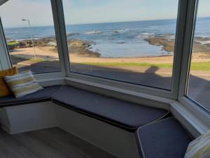 un posto a sedere vicino alla finestra con vista sull'oceano di Beach lodge Stunning Sea Views a Portballintrae