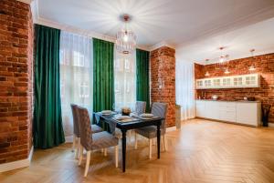 a kitchen and dining room with a table and chairs at Fancy Apartment Nikiszowiec in Katowice