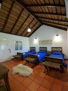 Habitación con 4 camas y sábanas azules. en Estancia San Agustin en Curuzú Cuatiá
