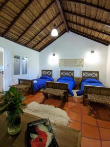 Habitación con almohadas azules, mesas y bancos en Estancia San Agustin en Curuzú Cuatiá