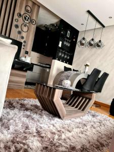 - un salon avec une table et des chaises sur un tapis dans l'établissement Vip apartman Zlatiborski konak, à Zlatibor