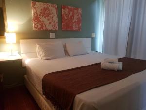 a bedroom with a large bed with a brown blanket at Hotel Casa Grande Itapira in Itapira