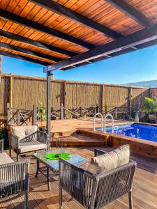 a patio with a table and chairs and a swimming pool at UĞURLUBUNGALOV in Sapanca