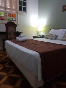 a bedroom with a large bed with two towels on it at Hotel Casa Grande Itapira in Itapira