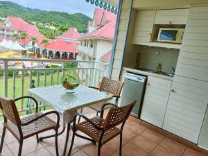 d'une terrasse avec une table et des chaises sur un balcon. dans l'établissement Le MaDja'Kaz - studio en résidence et bord de Mer - Sainte Luce Martinique, à Sainte-Luce