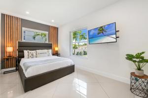 a bedroom with a bed and a tv on the wall at Unique Flagler's Mansion Pickleball Court L37 in Miami