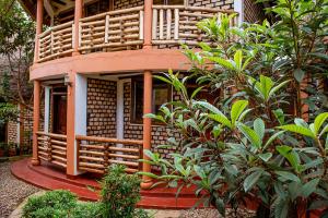 ein kleines Gebäude mit einer Veranda und einigen Pflanzen in der Unterkunft Elite Backpackers Services in Masaka