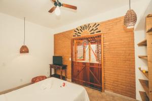a room with a white table and a brick wall at Vila Prosperidade Trancoso in Trancoso