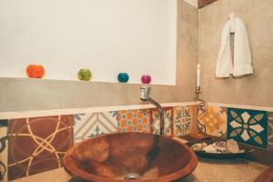 a bathroom with a copper sink and a candle at Vila Prosperidade Trancoso in Trancoso +26 photos