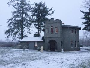 a large stone house with snow on the ground at Lavender Castle in Sequim