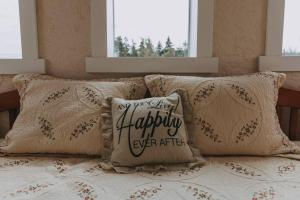 a bed with a pillow that says my very happy happily ever after at Lavender Castle in Sequim