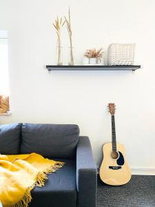 - un salon avec un canapé bleu et une guitare dans l'établissement Randers residence Sankt Andreas - 2 room apartment, à Randers
