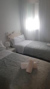 two beds in a bedroom with a piece of paper on the floor at Casa Lavanderas in Algodonales